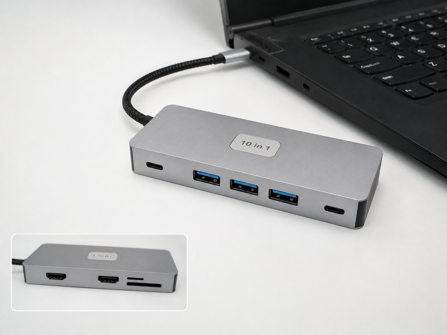 Silver 10-in-1 USB-C hub connected to a black laptop, with USB and card-reader ports visible